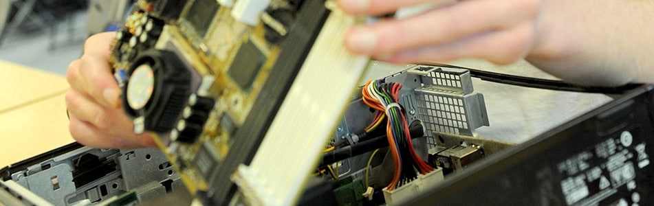 student taking the back off a computer